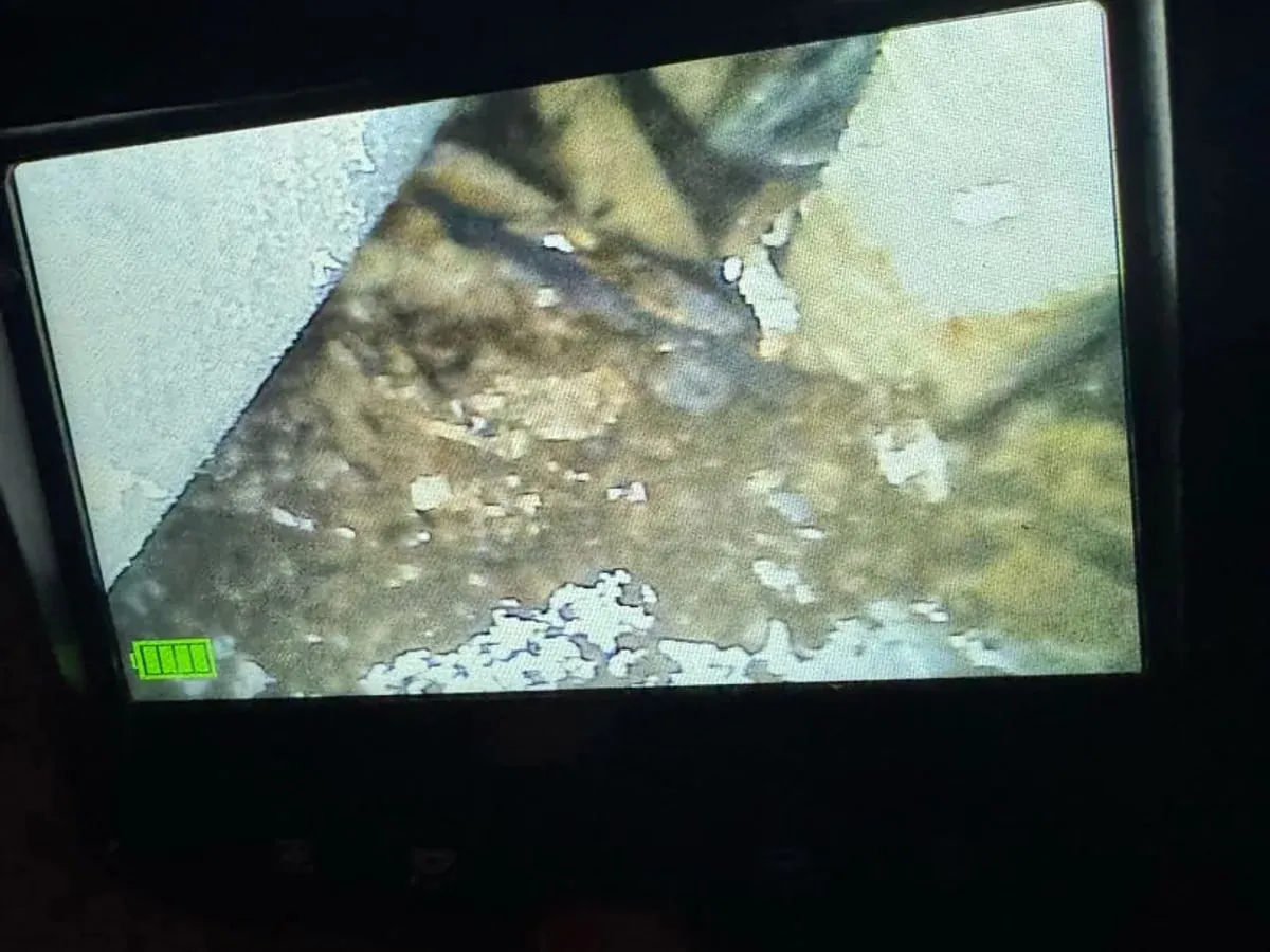 Endoscope screen showing a wet, dirty surface inside the pipe channel